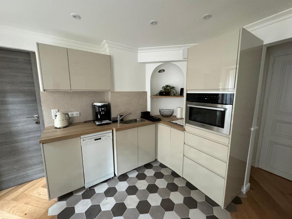 - une cuisine avec des placards blancs et un sol en damier dans l'établissement Appartement Paris 8 eme, à Paris