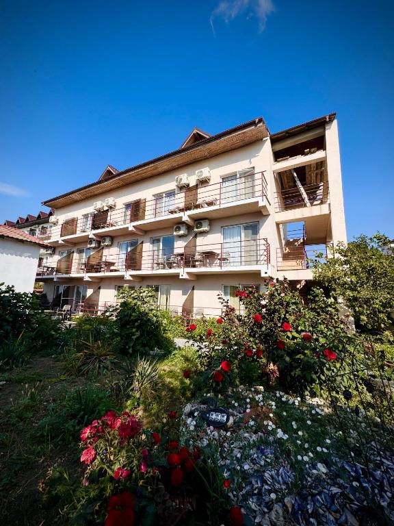 a large building with flowers in front of it at Casa Roman II by the sea in Costinesti
