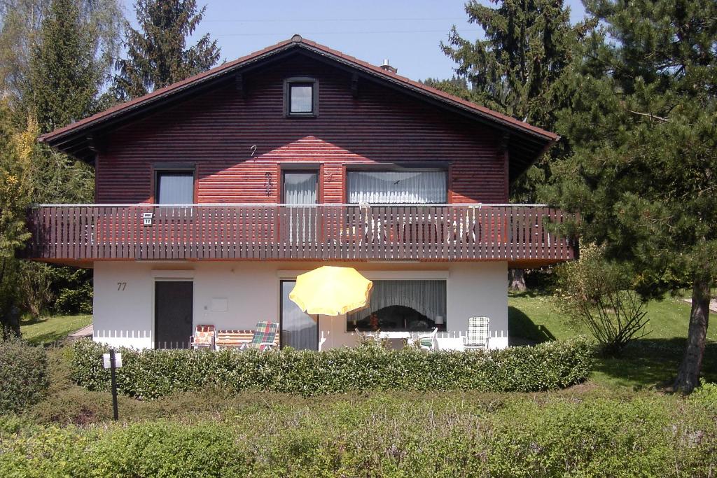 a large house with a balcony and an umbrella at Ferienwohnung Im Lamer Winkel in Arrach