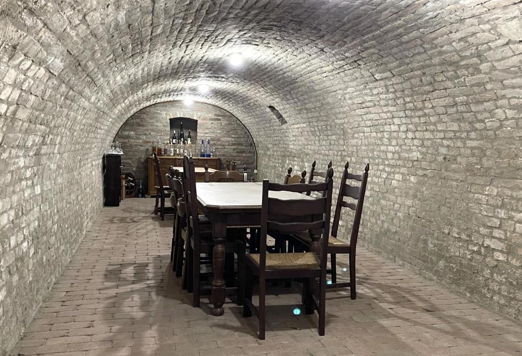 jadalnia ze stołem i krzesłami w tunelu w obiekcie Vadászkürt Vendégfogadó w mieście Alsónyék
