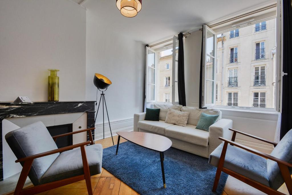 een woonkamer met een bank en een open haard bij Le Cœur des Dominicains - pour 6 centre de Nancy in Nancy