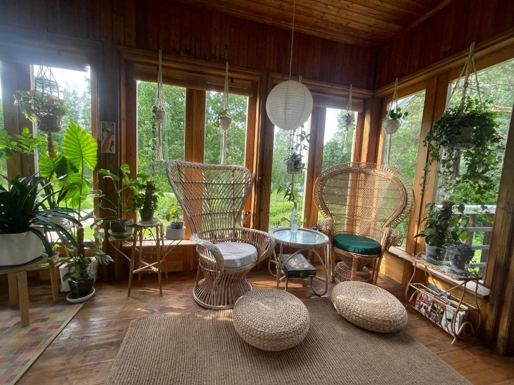 a room with chairs and a table and windows at Villa Kurenniemi in Taipalsaari