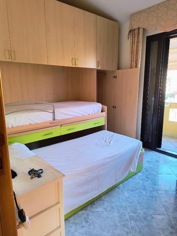 two beds in a room with cabinets and a desk at B&B Is Pranus a Mari Casa Privata in Solanas