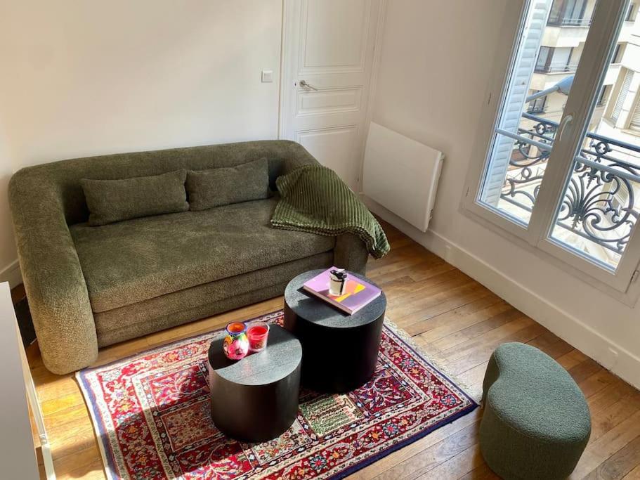 un salon avec un canapé et un tapis dans l'établissement Appartement - Cozy - 10 min de Paris, à Levallois-Perret