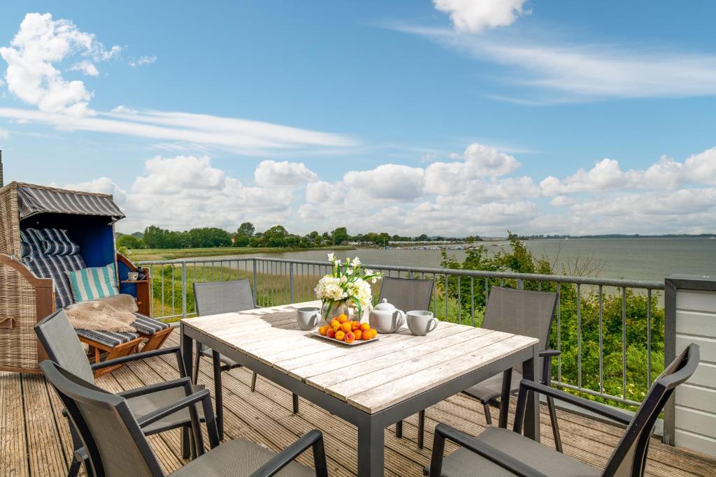 a table on a deck with a view of the water at Ferienwohnung Große Freiheit Olpenitz in Olpenitz