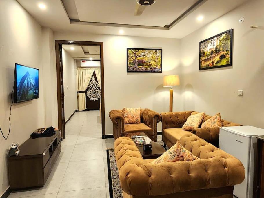 a living room with two couches and a television at Subtle 1Bed In Bahria Town in Rawalpindi
