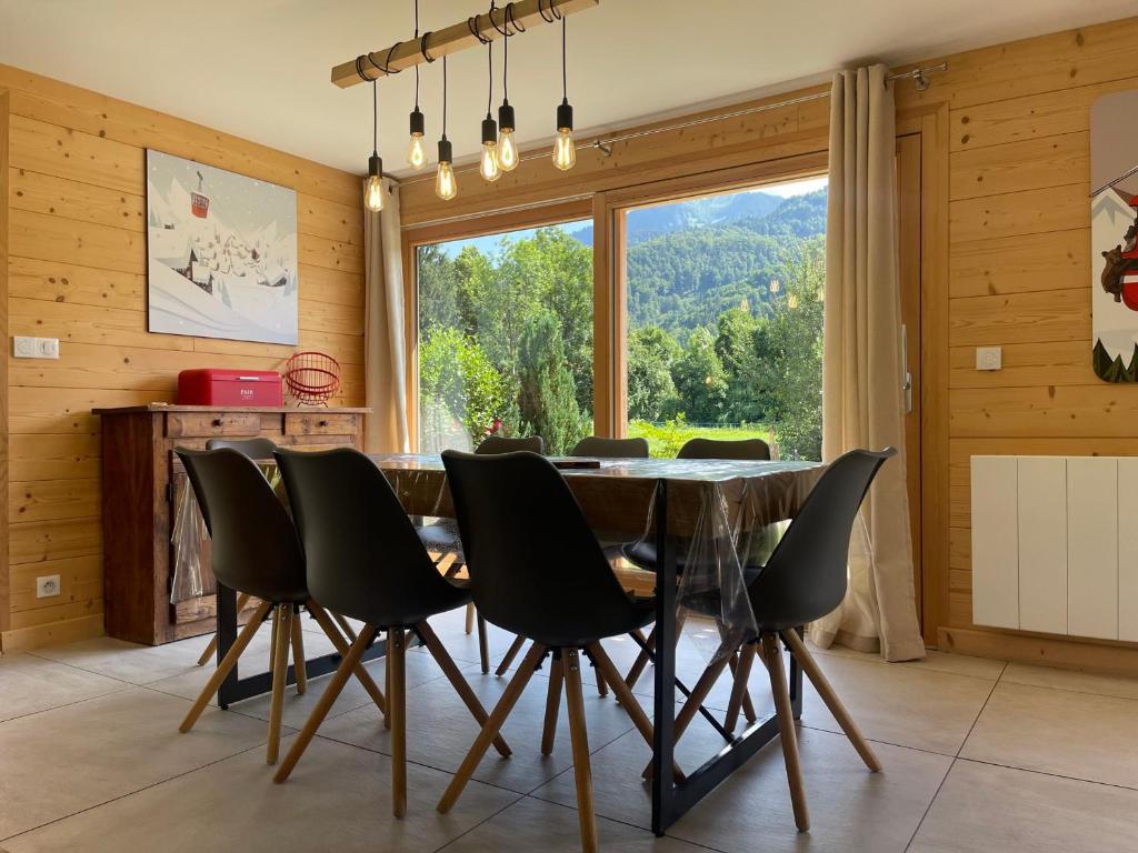 a dining room with a table and chairs and a large window at Chalet rénové spacieux près des commerces, à 200m du village et du lac, navette ski-bus gratuite - FR-1-624-118 in Samoëns