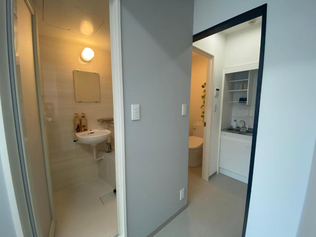 un bagno con un water, un lavandino e uno specchio di THE MOON Atami ad Atami