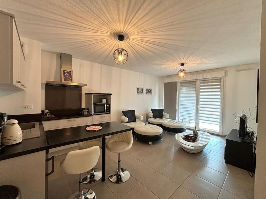 Il comprend une grande cuisine et un salon avec un comptoir et des chaises. dans l'établissement JASMIN avec parking à 200 m du centre, à Avignon