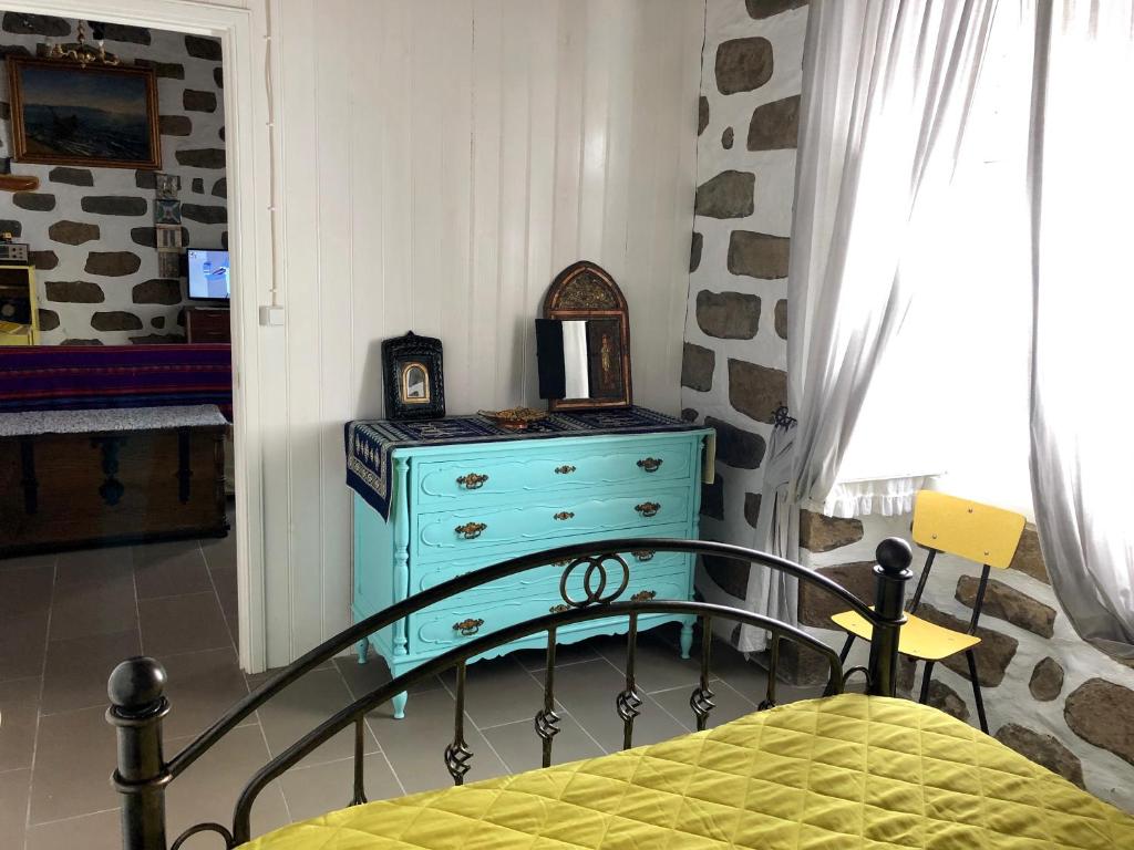 a bedroom with a bed and a blue dresser at Casa Auri in Faial da Terra