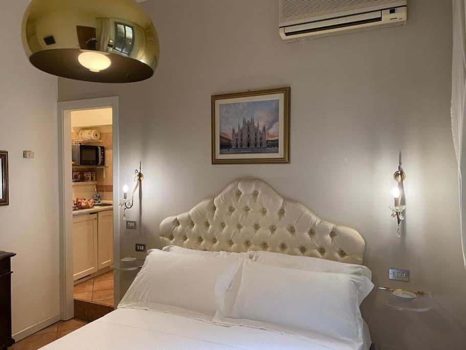 a bedroom with a white bed with a headboard at Duomo Prestige in Milan