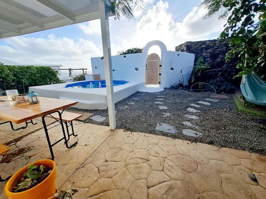 a white house with a table and a pool at Eco Casa Tierra in Tabayesco