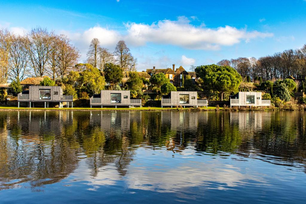 a view of a lake with houses in the background at Leeds Castle Lakeside Lodges in Broomfield