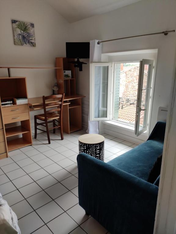- un salon avec un canapé bleu et un bureau dans l'établissement Au pti Logis Du Summer 2, à Brioude