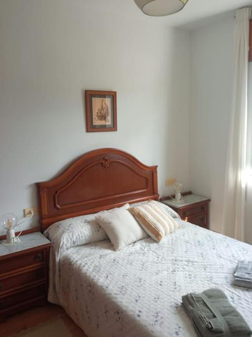 a bedroom with a large bed with a wooden headboard at Acogedora casita de campo in Bóveda