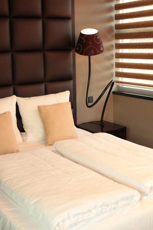 a bedroom with a bed with a black headboard and a lamp at Hotel Rosenmeer in Mönchengladbach