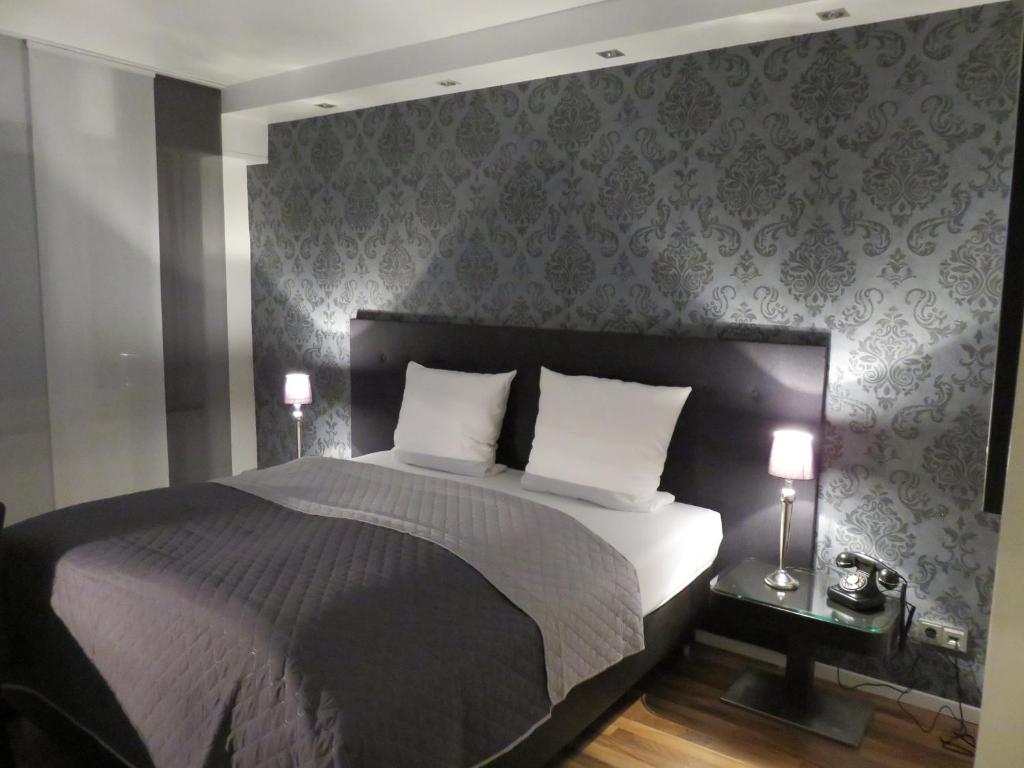 a bedroom with a large bed with two pillows at Hotel Rosenmeer in Mönchengladbach