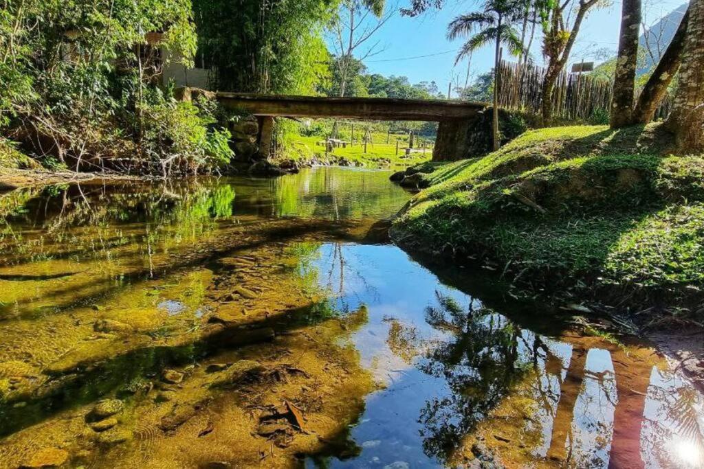 a reflection of a bridge in a body of water at Chácara Brisa do Rio 2 in Núcleo Colonial