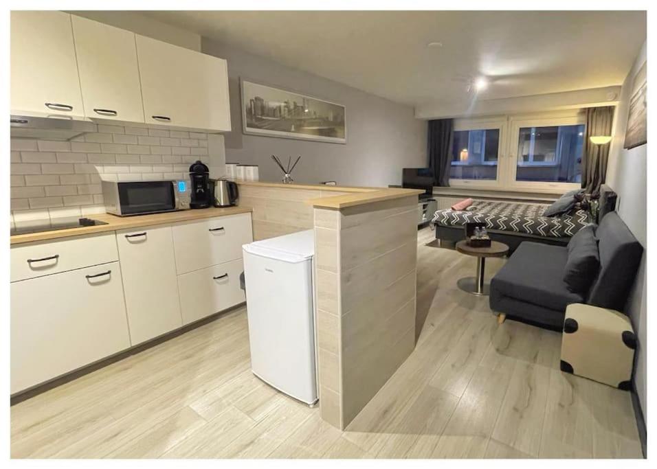 Una cocina y una sala de estar con un sofá. en Entourage Christinastraat, en Ostende