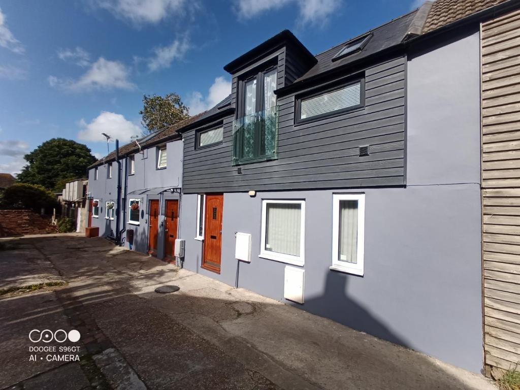 a white and gray building with orange doors on a street at BexLet in Bexhill