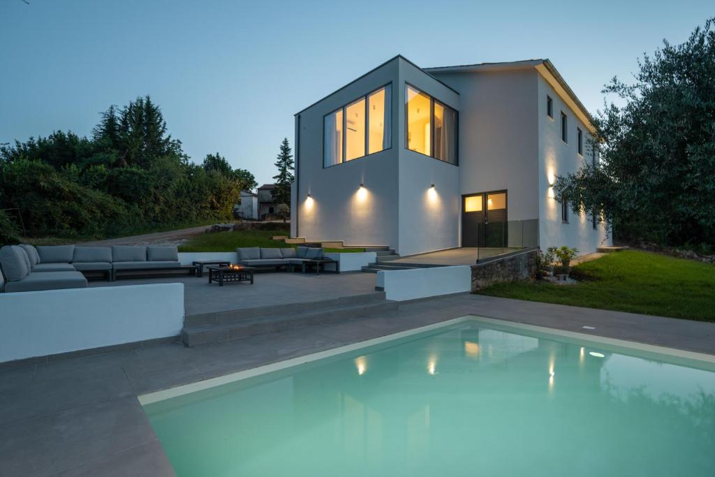 a house with a swimming pool in front of a house at Villa Nene in Benažići