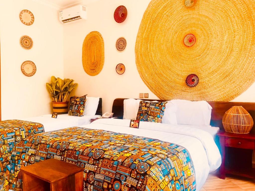 a room with two beds and plates on the wall at Kerama Silent Lodge in Arusha