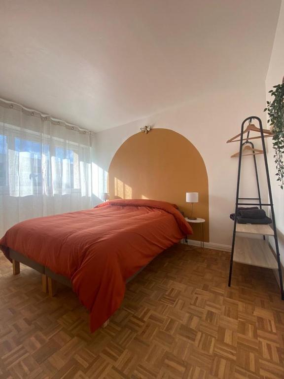 - une chambre avec un lit doté d'un couvre-lit rouge et d'une échelle dans l'établissement Grand appartement 6 personnes à 5min de Versailles avec parking privé, à Le Chesnay