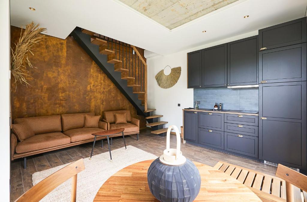 ein Wohnzimmer mit einer Couch und einer Treppe in der Unterkunft Kotedžas prie jūros in Palanga