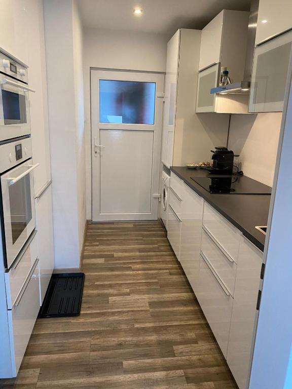 a kitchen with white cabinets and a door at DC Room Birgit in Zeltweg