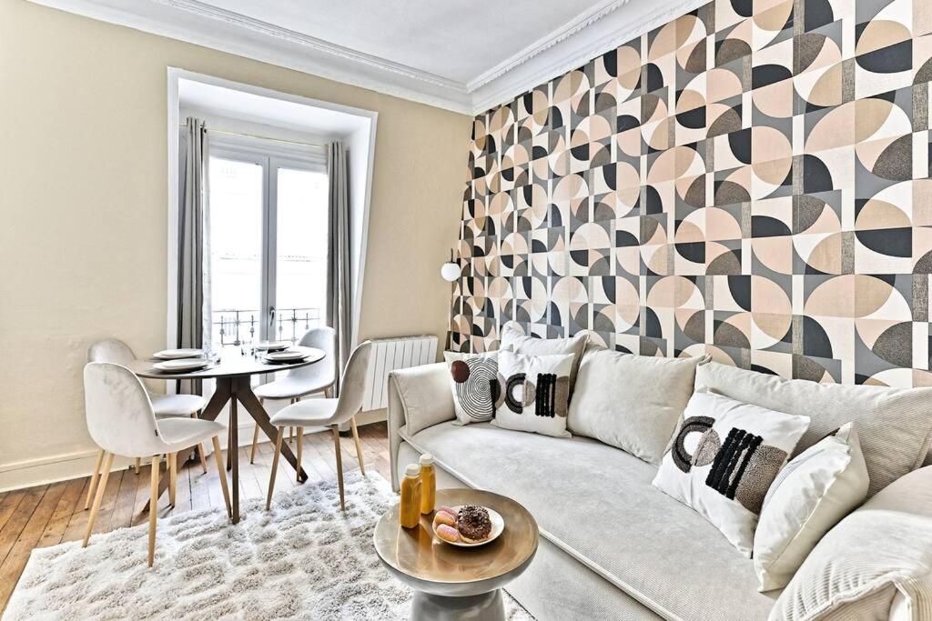 un salon avec un canapé et une table dans l'établissement Appartement cosy face de Paris Montparnasse, à Paris