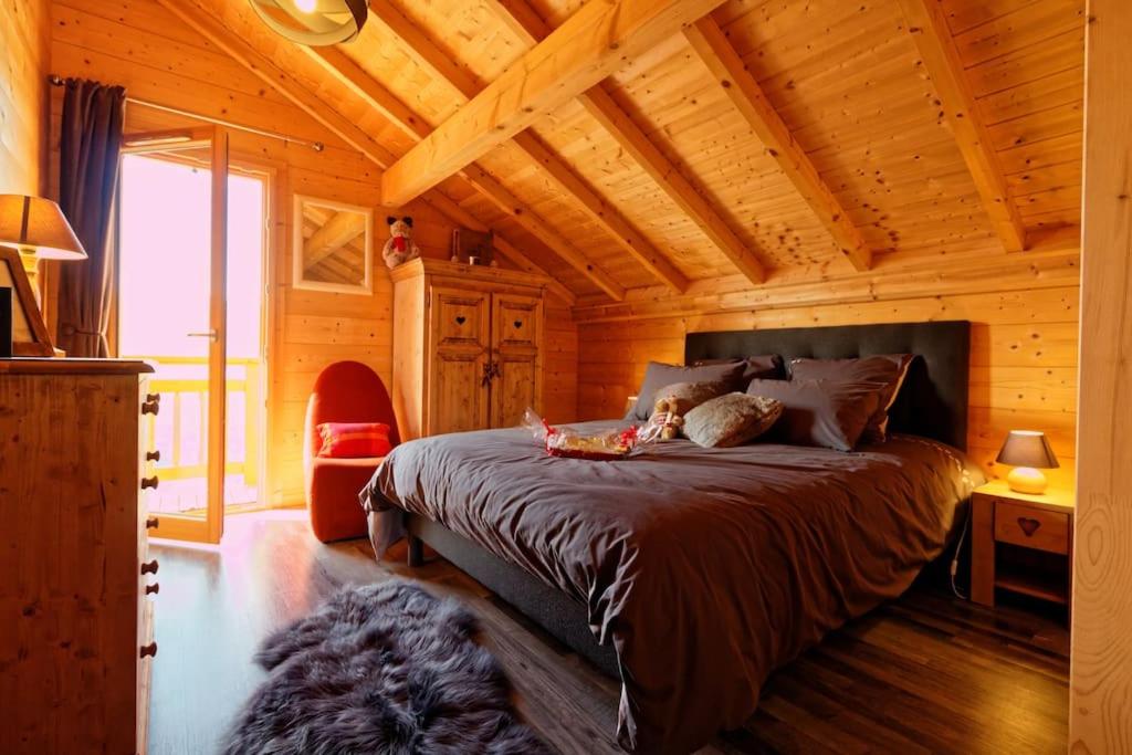 a bedroom with a bed in a wooden cabin at Chalet d'exception, spa et sauna, 4p in La Bresse