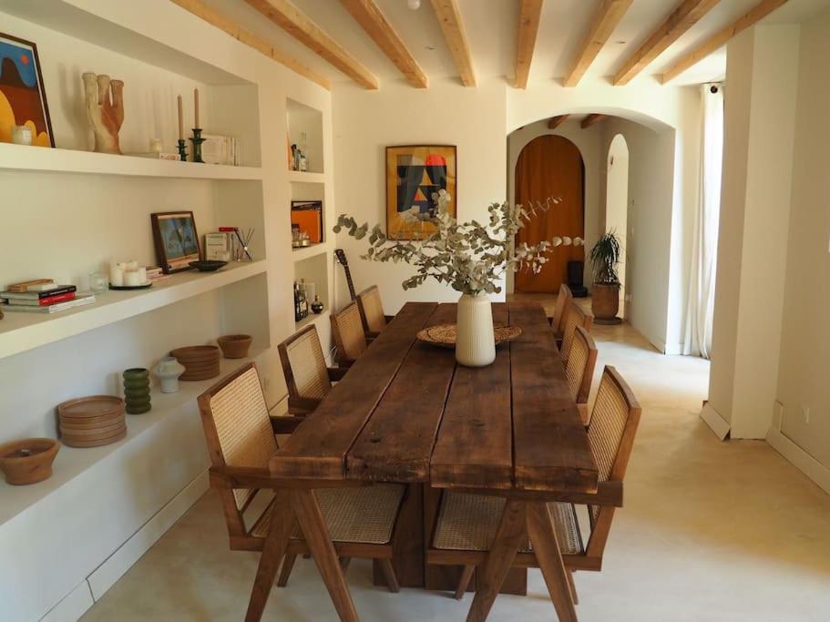 ein Esszimmer mit einem Holztisch und Stühlen in der Unterkunft Charmante Grange aux Monts d'Or in Collonges-au-Mont-dʼOr