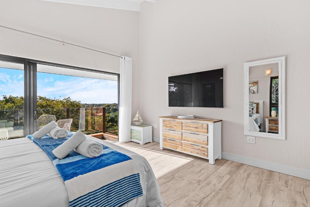 a bedroom with a bed and a large window at San Lameer Villa - 14306 - 5 Bedroom Luxury - 10 pax - San Lameer Rental Agency in Southbroom