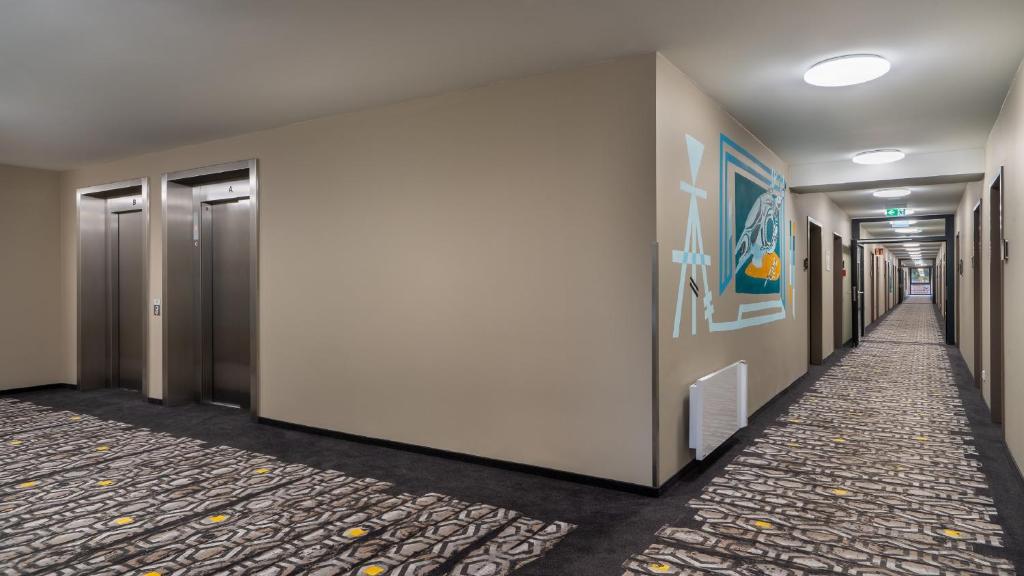 a corridor of an office building with a hallway at Holiday Inn - the niu, Timber Esslingen by IHG in Esslingen