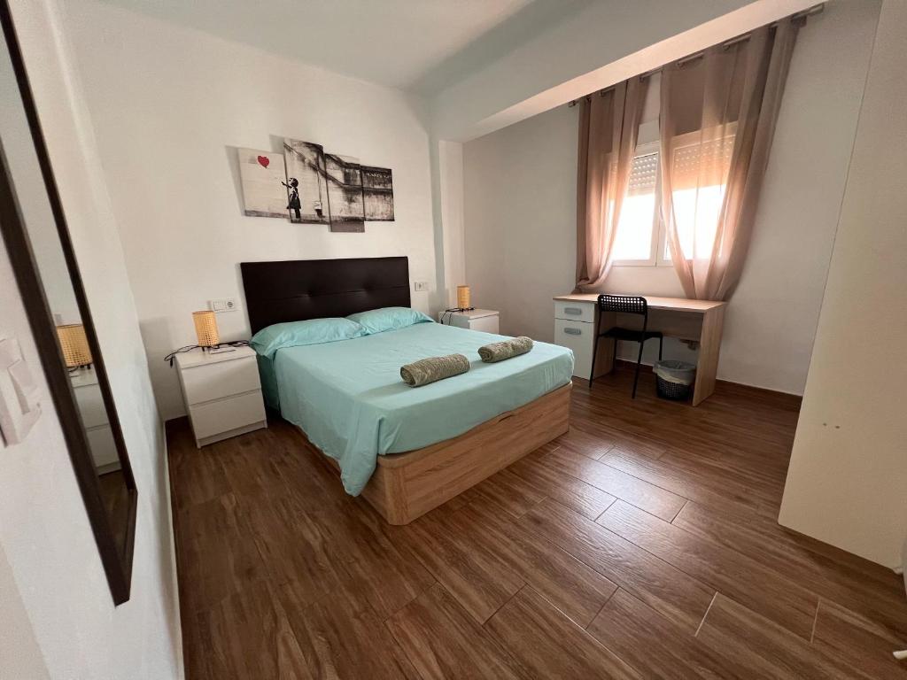 Un dormitorio con una cama y un escritorio y una ventana. en Brisa & Beach a 3 Min de la Playa Zapillo, en Almería