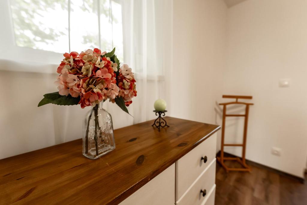 a vase of flowers sitting on a wooden counter at Római Home in Hévíz