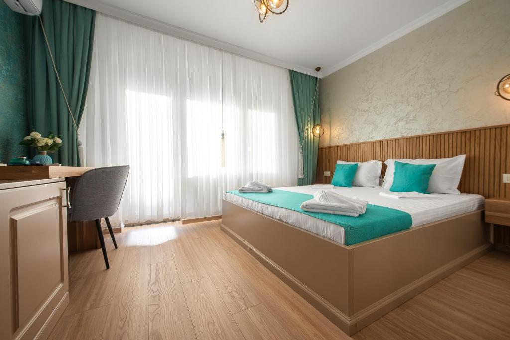 a hotel room with a bed and a desk at Thaya Rooms in Mangalia