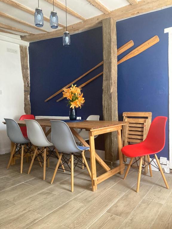 a dining room with a wooden table and chairs at Lime Tree Cottage in Tillingham