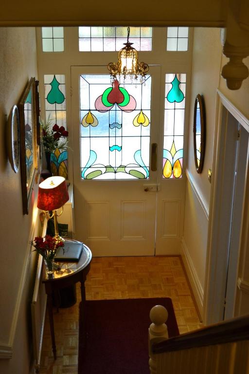 a hallway with a door with a stained glass window at Knightsrest in Burnham on Sea