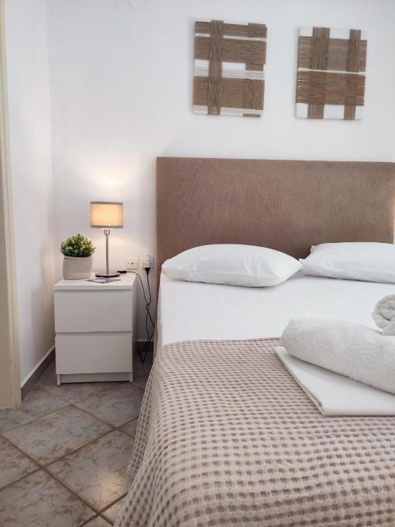 a bedroom with a bed and a night stand with a lamp at Feidiou 1 vol II in Egina