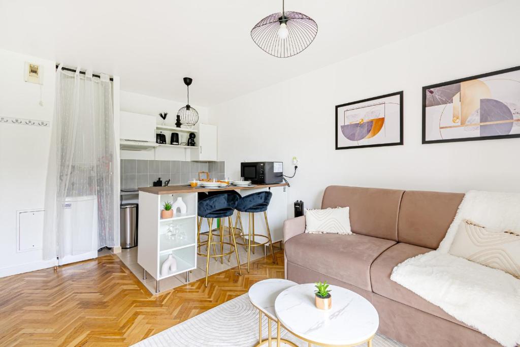 un salon avec un canapé et une cuisine dans l'établissement Sweet cocon à Disney, à Montévrain