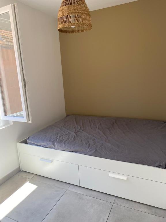 un lit dans une chambre avec une fenêtre dans l'établissement Appartement T2 Valras plage 400m de la plage, à Valras-Plage