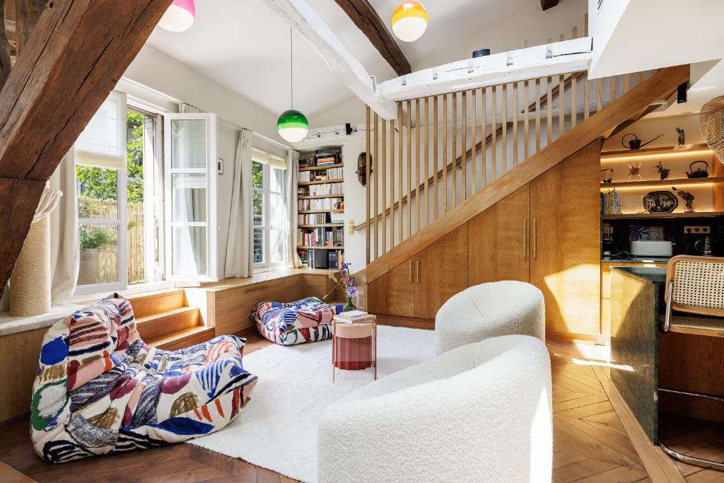 - un salon avec des chaises blanches et un escalier dans l'établissement Loft Chic & Cosy, Paris 9, Anvers - Montmartre, à Paris