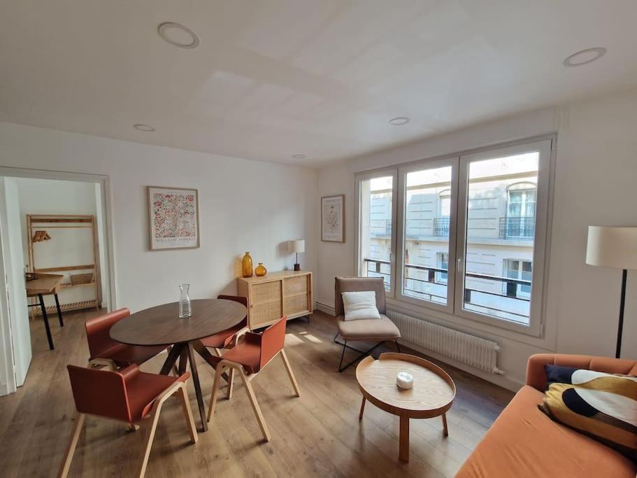 un salon avec une table et des chaises dans l'établissement Élégance moderne 15e - Confort près Tour Eiffel, à Paris