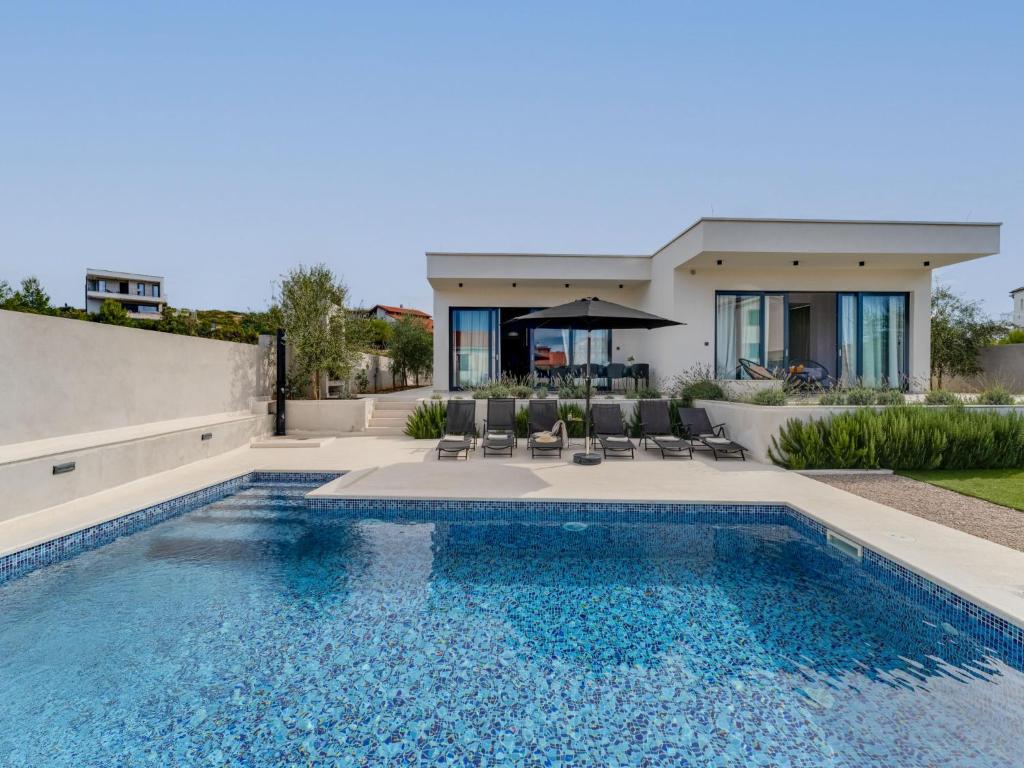 a swimming pool in front of a house at Villa Inizio by Interhome in Brodarica