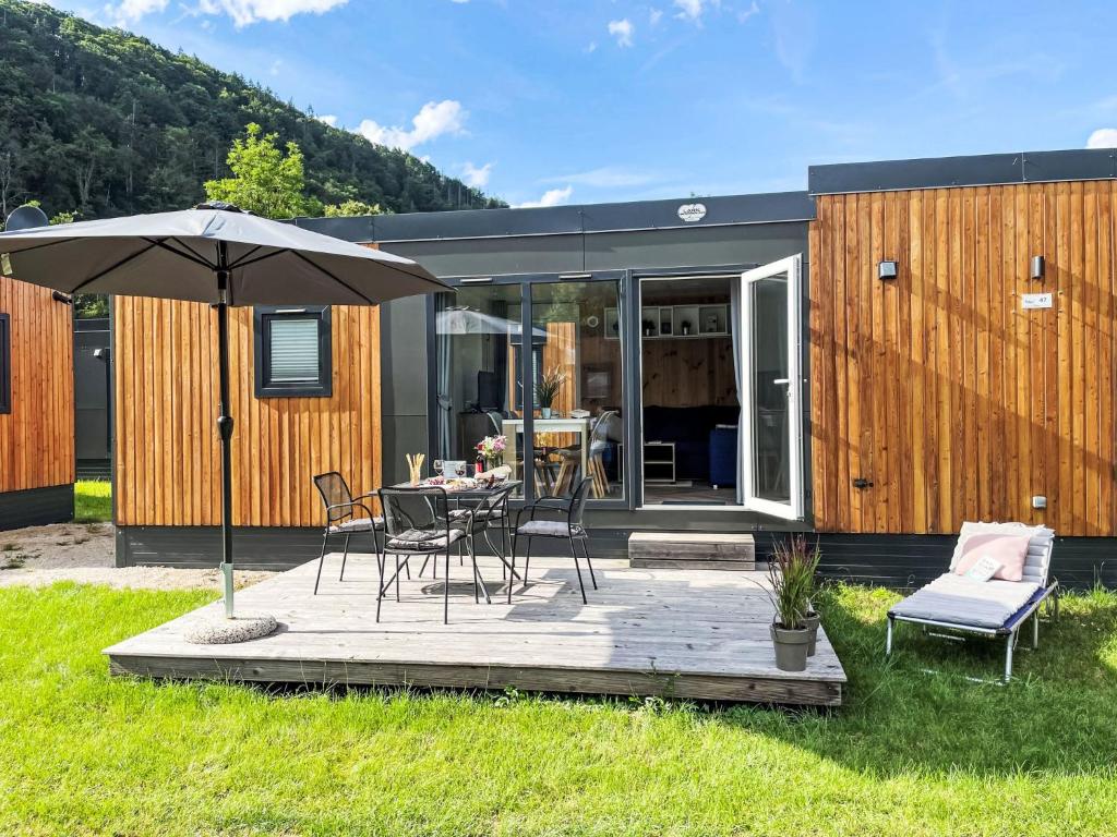 a house with a table and chairs and an umbrella at Holiday Home Tiny Haus Sonnenplatz by Interhome in Riedenburg