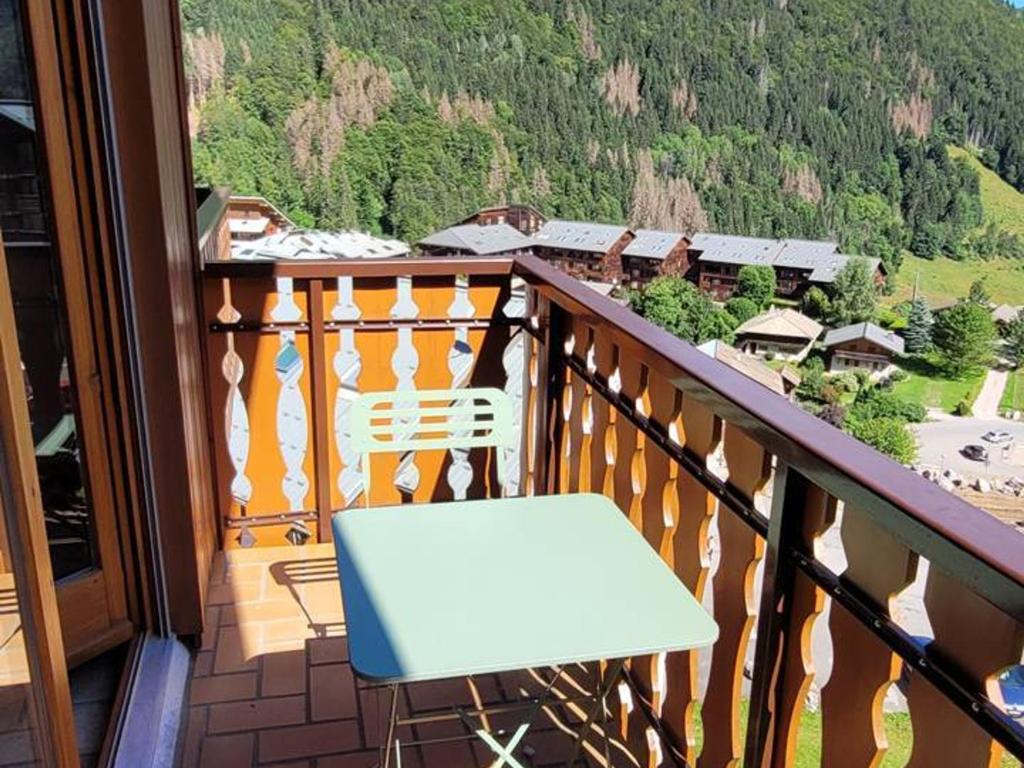 une chaise blanche assise sur un balcon avec vue dans l'établissement Location 2 pièces cabine mezzanine à Saint-Jean-d'Aulps, pied de pistes, parking, animaux admis - FR-1-573-29, à Saint-Jean-dʼAulps