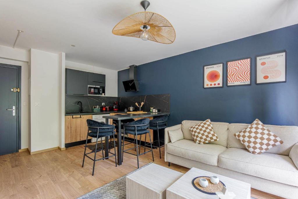 un salon avec un canapé et une cuisine dans l'établissement Appartement Croisé Laroche - 5 min de Lille, à Marcq-en-Barœul