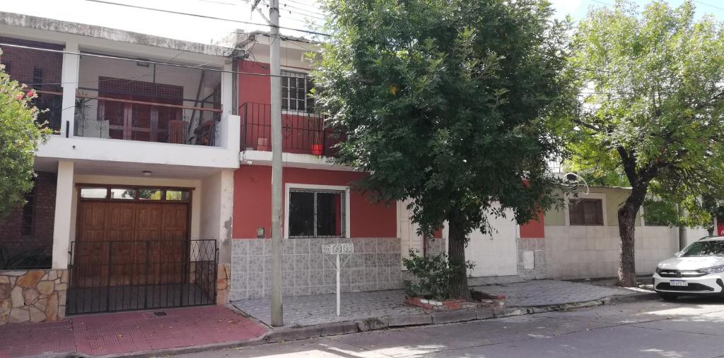 a red and white house with a car parked in front of it at Casa particular Flavio in Salta