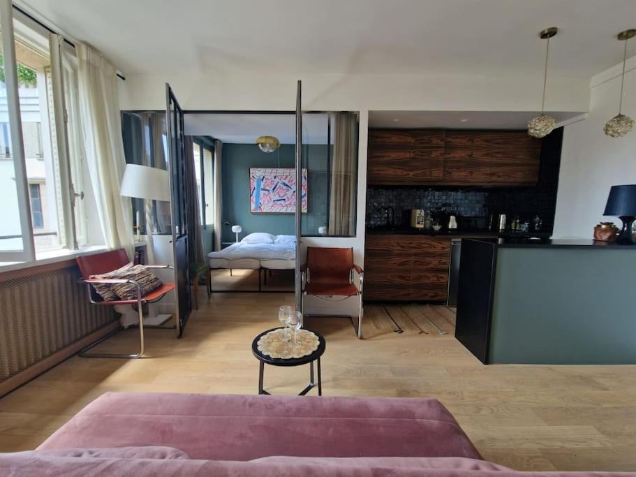 - un grand salon avec un lit et une table dans l'établissement Luxe parisien, charme 16e - À 2 pas du Trocadéro, à Paris